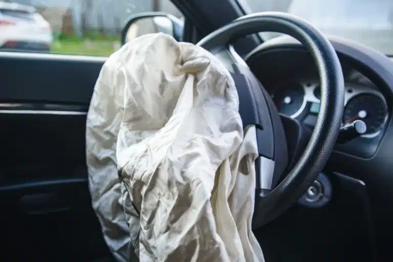 Deployed airbag on steering wheel after car accident interior