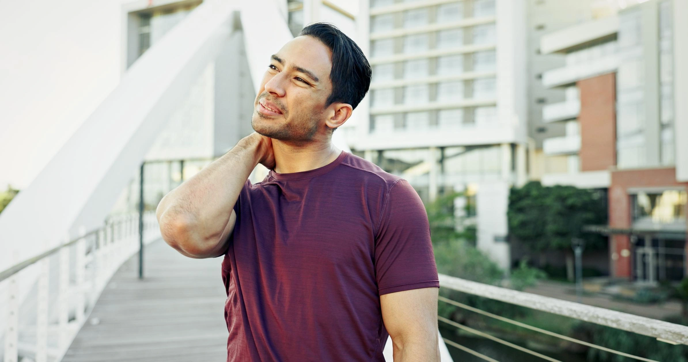 Man holding his neck in pain outdoors, representing an aggravated injury caused by a car accident.
