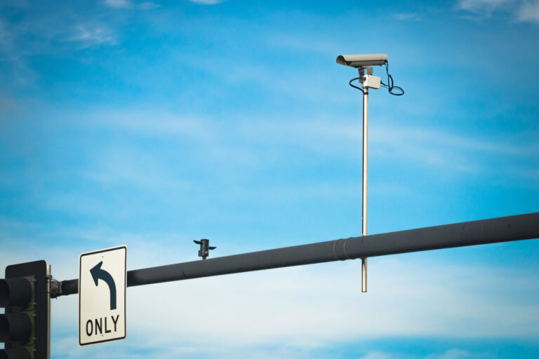 Red light traffic camera mounted above a Phoenix, Arizona intersection monitoring vehicles for traffic violations